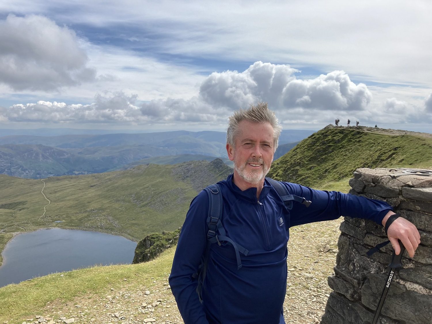 Paul Kenny, landscape and seascape painter, on a hilltop above a mountain tarn